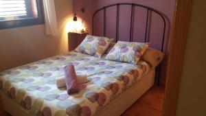 ein Schlafzimmer mit einem Bett mit einer Puppe drauf in der Unterkunft Apartamento Gis con chimenea in Ribes de Freser