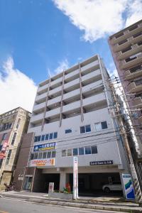 un edificio alto gris en una calle de la ciudad en Coral Gate in Kume コーラルゲートイン久米, en Naha