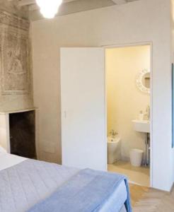 1 dormitorio con 1 cama y baño con lavamanos en Il Piccolo Cavour Charming House B&B, en Arezzo
