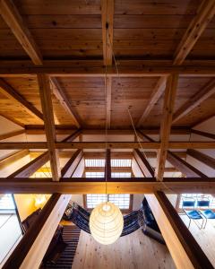 a chandelier hangs from thefters of a wooden ceiling at Villa Iizuna Plateau -飯綱高原の山荘- in Nagano