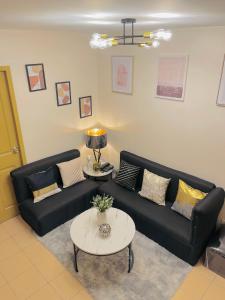 a living room with a black couch and a table at 4138 Davao City 2bedroom unit 8 Spatial Maa by Filinvest in Davao City
