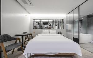 a bedroom with a large bed and a bath tub at Cacao Hotel in Incheon