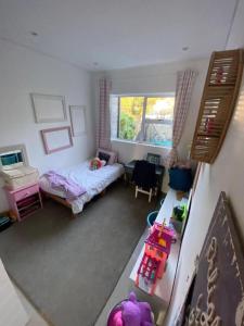 een kleine slaapkamer met een bed en een raam bij Spacious Home with Sea View in Glen Navar in East London