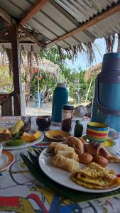 einen Tisch mit Teller mit Lebensmitteln darüber in der Unterkunft Le A, Trou du Prophète in Mitsamiouli