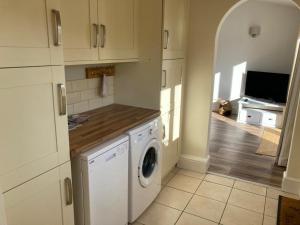 uma cozinha com máquina de lavar e secar roupa num quarto em The Stables em Metheringham
