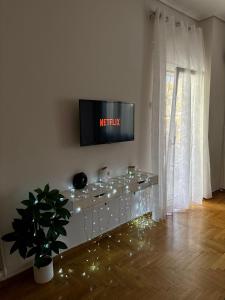 a living room with a television on a wall at apartment Alimos near the sea in Alimos