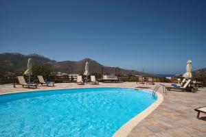 a swimming pool with a view of the mountains at Amorgion Village in Katapola