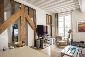 a living room with a large wooden beam at Cosy appart Odéon Saint Germain in Paris