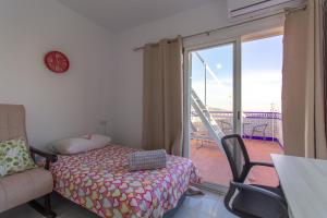 a bedroom with a bed and a balcony with a sliding glass door at RentitSpain Casa Abanico a pasos de Castillo de Salobreña in Salobreña