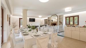 ポンテコルヴォにあるTENUTA ESDRA 20, Emma Villasの長いテーブルと白い椅子のあるダイニングルーム