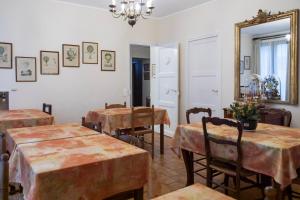 a dining room with tables and chairs and a mirror at Cit'Hotel Aéro-Hotel in Le Blanc-Mesnil