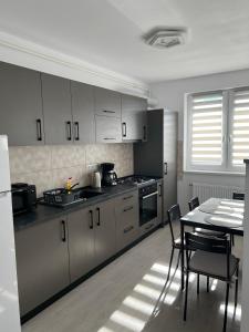 uma cozinha com armários brancos e uma mesa com cadeiras em Arini Cozy Corner em Selimbar