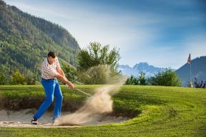 a man playing a game of sand on a golf course at MONDI Hotel am Grundlsee in Grundlsee