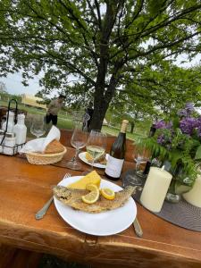 a wooden table with a plate of food and wine at Carul cu Stele-Glamping 