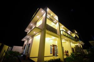 un grand bâtiment avec des lumières allumées la nuit dans l'établissement Sai Residence, à Jaffna