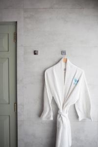 a white robe hanging on a wall next to a door at Angel Beach Unawatuna in Unawatuna