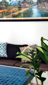 a painting of a couch with pillows and a plant at Le Watwam Hotel in Siem Reap