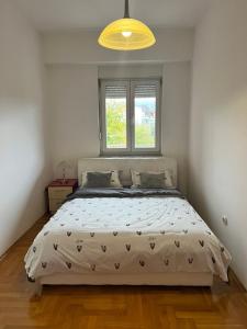 a bedroom with a large bed with a window at Apartman Sudnica Banja Luka in Banja Luka