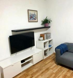 salon z białym centrum rozrywki z telewizorem z płaskim ekranem w obiekcie cozy apartment w Splicie