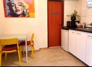 kuchnia ze stołem, 2 krzesłami i drzwiami w obiekcie cozy apartment w Splicie