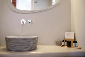 a bathroom with a white sink with a mirror at Amorgion Village in Katapola