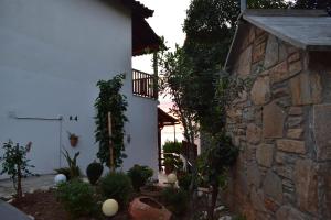 a garden with plants and a stone building at Alisaxni Seaside Studio in Agios Ioannis Pelio