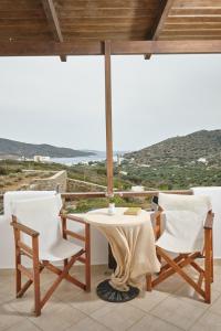 a table and chairs with a view of the ocean at Amorgion Village in Katapola