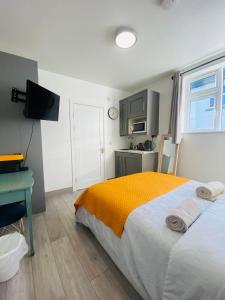 a bedroom with a bed and a desk and a kitchen at CROKE PARK STUDIO in Dublin