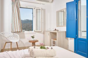 a room with a blue door and a table and a window at Amorgion Village in Katapola