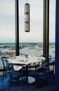 a dining room with a table and chairs and a window at Clarion Hotel Draken in Gothenburg