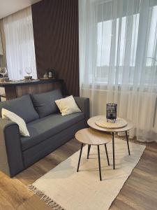 a living room with a couch and a table at Vienibas Apartaments in Krāslava