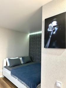 1 dormitorio con 1 cama y TV en la pared en Vienibas Apartaments, en Krāslava
