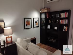 ein Wohnzimmer mit Sofa und Bücherregal in der Unterkunft Casa Samarotto in Reggio nell'Emilia