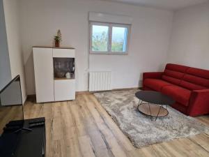 a living room with a red couch and a table at Ness'house in Tregueux