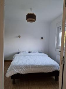 - une chambre dotée d'un lit avec un mur blanc dans l'établissement Ness'house, à Trégueux