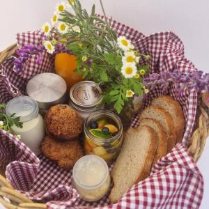 Penhill的住宿－Frieden-Hof Guest Accommodation，包括面包、果酱和鲜花的食品篮