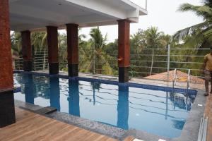 a swimming pool in front of a building at Casa sportsman Appament in Calangute