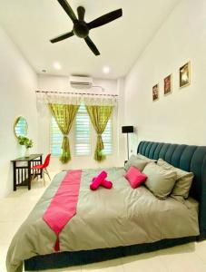 ein Schlafzimmer mit einem großen Bett mit rosa Kissen in der Unterkunft Homestay Semi D Dekat Area Sepat in Kuantan