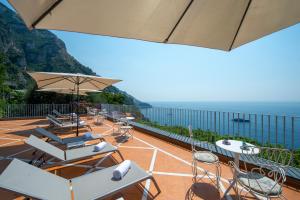 a patio with chairs and tables and the ocean at Il Barilotto in Positano