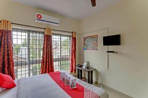 a bedroom with a bed and a tv and a window at OYO Flagship 15148 Sky Pix Near Kasi Talkies in Chennai