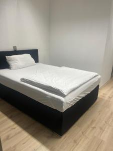 1 cama en un dormitorio con suelo de madera en Hannover 24 S, en Hannover