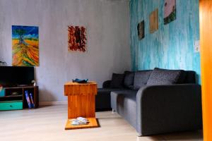 ein Wohnzimmer mit einem Sofa und einem Tisch in der Unterkunft Casa Colore with Garden and Courtyard in Wiesbaden