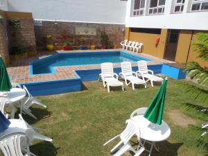 a group of lawn chairs and a swimming pool at Victor Hotel in Villa Carlos Paz