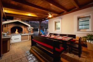 cocina con mesa de comedor y chimenea en VILLA MILLA with private pool, jacuzzi, sauna, gym, max. 8 person, en Srinjine