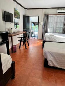 a hotel room with two beds and a desk and a table at Nice view guesthouse in Vang Vieng