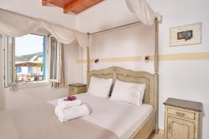 a bedroom with a bed with towels on it at Amorgion Village in Katapola