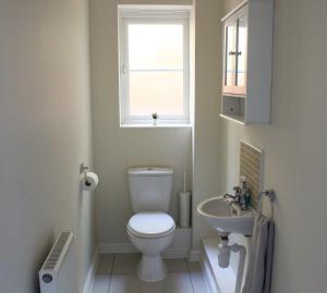 a bathroom with a toilet and a sink and a window at Progress Grove in Huntington