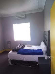 ein Schlafzimmer mit einem großen Bett und einem großen Fenster in der Unterkunft Prime Guest Inn in Benoni