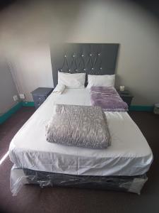 Schlafzimmer mit einem großen weißen Bett mit Kopfteil in der Unterkunft Prime Guest Inn in Benoni
