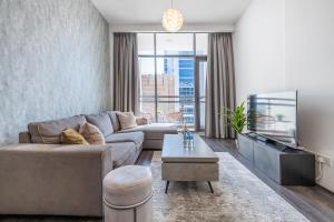 a living room with a couch and a tv at 1 Bedroom Apartment with city view in Dubai